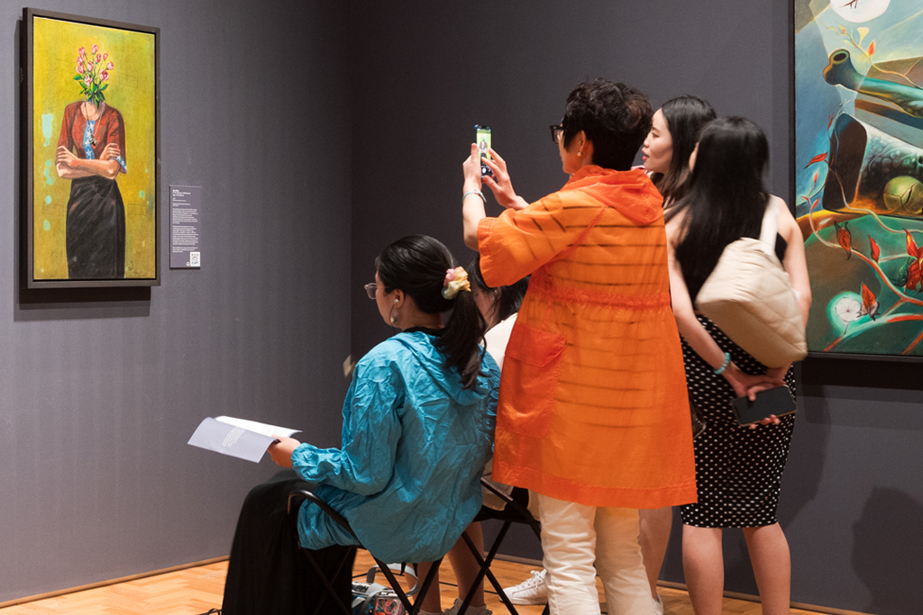 A group of people examining an art work - practising slow looking and mindfulness together allows people to share different perspectives and connect